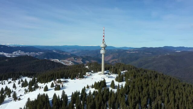4K Aerial winter view of Rhodope Mountains and Snezhanka tower near resort of Pamporovo, Smolyan Region, Bulgaria