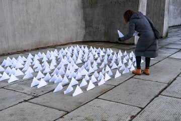 Unrecognizable woman choosing a paper boat from an outdoor exhibition
