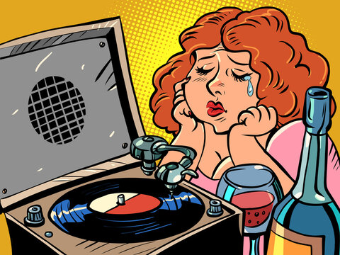 Sad red-haired woman listens to music on the gramophone and drinks wine. Lonely evening. Plate