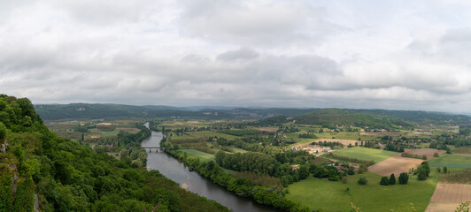 panorama view of the picturesque Dordogne Valley with river and bridge in dense green summer forest