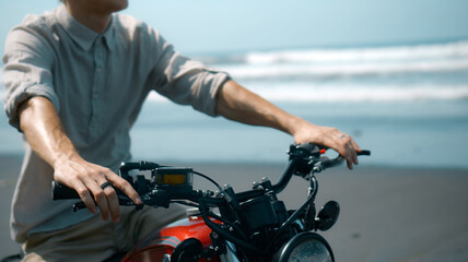 Fototapeta na wymiar European young man hold motorbike handlebars while touching gas handle and brake lever ahead of trip