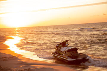 Motorówka zaparkowana na brzegu morza przy zachodzie słońca - obrazy, fototapety, plakaty