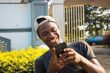 Excited african american millennial Young man hold smartphone feel euphoric reading good news,...
