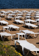 White sunbeds on empty sandy beach with no people 