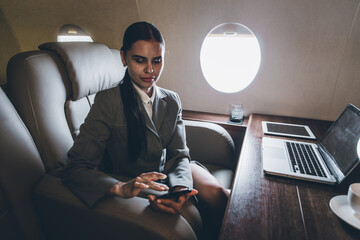 Businesswoman flying on her private jet. Business woman flying on the private airplane. Working...