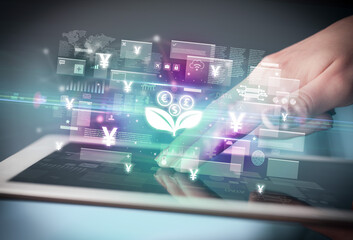 Fototapeta premium Close-up of a hand using tablet, currency concept