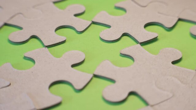 Upside down pieces of a jigsaw puzzle on a green background on a green background