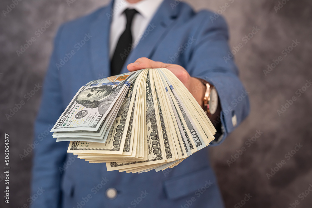 Wall mural businessman the dressed in the brands has a large amount of dollars he wants to invest