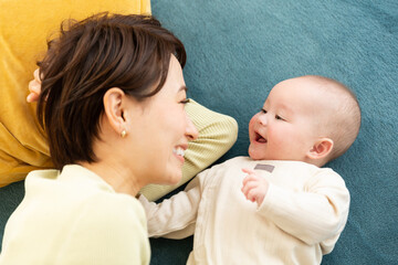寝転ぶ赤ちゃんと母親