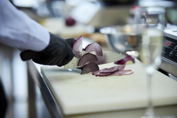 The cook cuts the onion. Cooking process. 