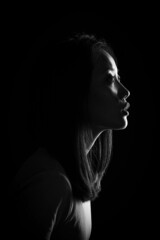 Silhouette of an Asian girl. Portrait of a woman on a dark background