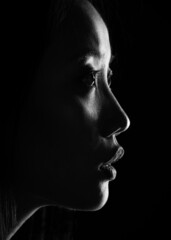 Silhouette of an Asian girl. Portrait of a woman on a dark background