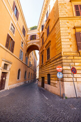 Narrow street with beautiful arch at residential district at old town in Rome. Traveling Italian landmarks concept. Architecture and buildings in Rome