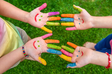 Hands of a child with a drawn smile. Selective focus.