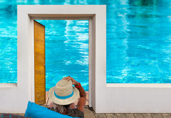femme au chapeau de paille au bord de la piscine 