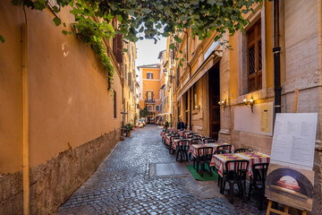 Narrow street with cafe and small shops in Rome. Italy travel concept, visiting cozy places