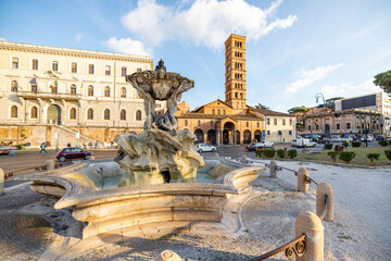Fountain of the Tritons and Church of Santa Maria in Cosmedin in Rome at sunset. Concept of...
