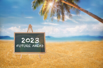 2023 future ahead on chalkboard with coconut palm tree on tropical beach with cloudy sky background, happy holiday travel concept and natural relaxation idea