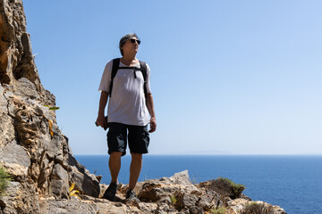 a man walks along a rocky path along the seashore, Greece, Crete. Active lifestyle concept