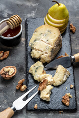 Blue cheese with pears, walnuts, nuts and honey. French cuisine. Vegetarian lunch. vertical image. top view. place for text