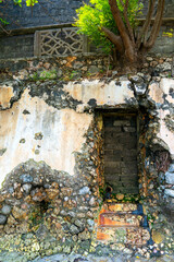 Fototapeta na wymiar weathered wall with plaster and exposed rock coral stonework