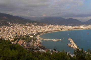 Turkey, Alanya, 30.08.2021: The city of Alanya (Turkey) and the Mediterranean Sea from a bird's eye view. Densely populated city. Travel to Turkey. Sea port