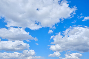 Background cumulus clouds against a blue sky illuminated by sunlight.
