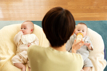 双子の赤ちゃんを授乳する母親