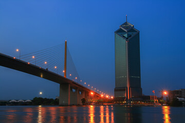 Fototapeta na wymiar Rama 9 cable-stayed bridge with Kasikorn Bank Building at night time, is a one most popular landmark on the Chao Phraya Riverside