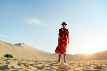 Fototapeta na wymiar asian woman walking in desert under blue sky