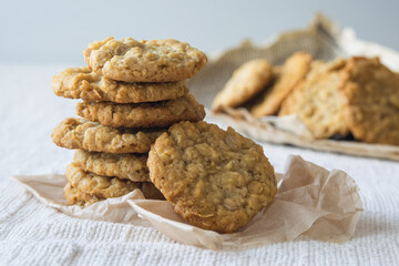 Stack of delicious oatmeal cookies with cereals on light background, selective focus