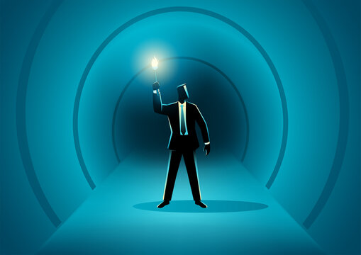 Businessman walking in the dark tunnel holding a torch