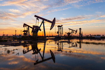 in the evening, oil pumps are running, The oil pump and the beautiful sunset reflected in the...