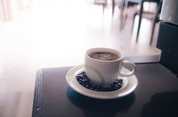 Fresh tasty espresso cup of hot coffee with coffee beans with orange flar