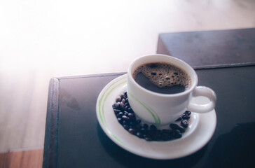 Fresh tasty espresso cup of hot coffee with coffee beans with orange flar