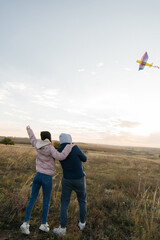 A happy couple flies a kite and spends time together outdoors in a nature reserve. Happy relationships and family vacations. Freedom and space.