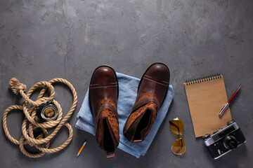 Travel stuff set and old boots on floor background texture. Trip goods as concept idea