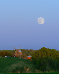 Wschód księżyca nad wzgórzem z wiatrakiem na Kaszubach w Polsce