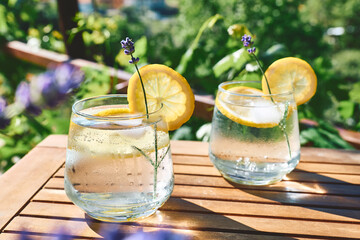 Cool lavender homemade lemonade with lemon slices and lavender flower. Healthy organic summer soda drink. Detox water. Diet unalcolic coctail.