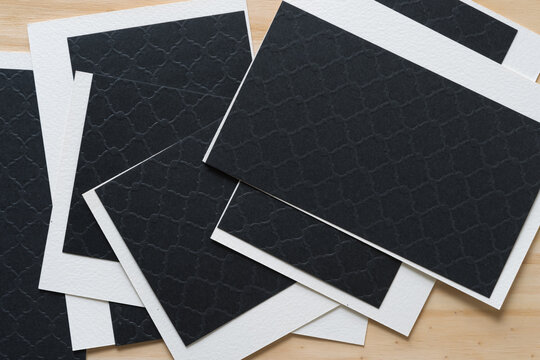 Black And Ivory (or White) Card Stock On A Wooden Background