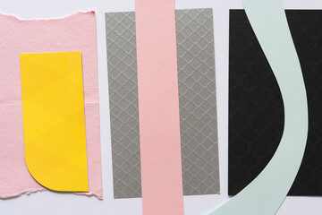 abstract background with cardboard, paper, and card stock (in silver, pink, black, and yellow)