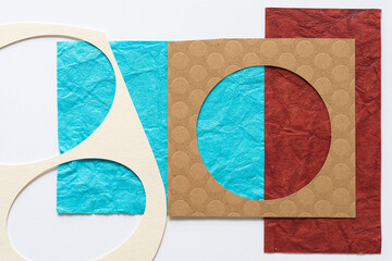 two stencils (oval, circle) on paper with texture (in blue and red)