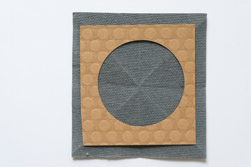 two isolated shapes resting on one another (circle frame over gray ground)