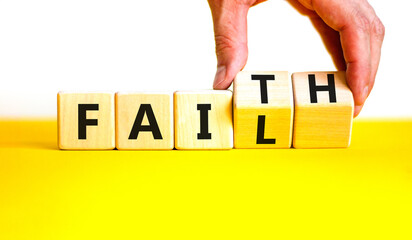 Faith instead fail symbol. Businessman turns wooden cubes and changes the concept word Fail to Faith. Beautiful yellow table white background. Business and faith instead fail concept. Copy space.