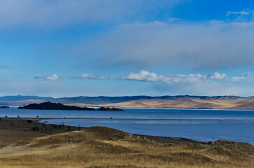 Lake Baikal during the beginning of ice melting. Beautiful view of rock on Olkhon Island on a cloudy spring day.