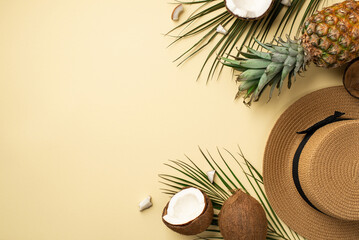 Summer holidays concept. Top view photo of hat fresh tropical fruits cracked coconuts pineapple and green palm leaves on isolated beige background