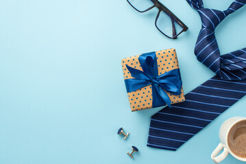 Father's Day concept. Top view photo of polka dot gift box with ribbon bow cup of coffee spectacles cufflinks and blue necktie on isolated pastel blue background