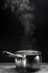 Steaming pot on black background, Hot food concept. Bowl of hot steam of hot soup with smoke