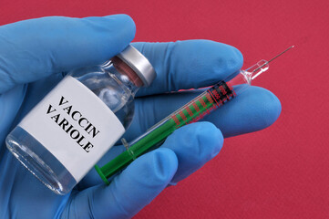 Concept de flacon de vaccin contre la variole et seringue dans une main gantée en gros plan sur...