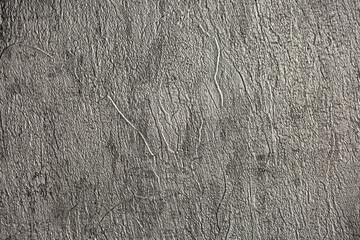 Gray background of decorative plaster with abstract spots. Unusual silver wall texture with beautiful patterns, creative surface background. Dressing coating for building cladding.